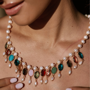 Girocollo con perle naturali realizzata a mano con filo in ottone e tecnica dei nodi ad orefice. Charms con cristalli colorati e perle.